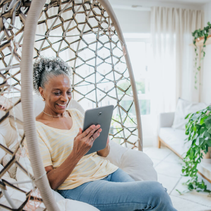 Woman looking at tablet in a chair